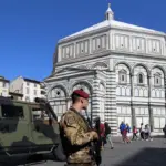 Прапор ЄС на тлі символічного зображення загрози гібридної атаки